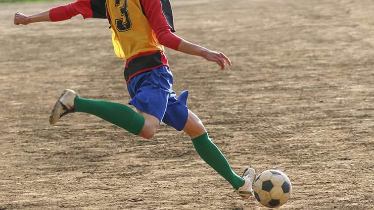 部活のサッカーをする男性